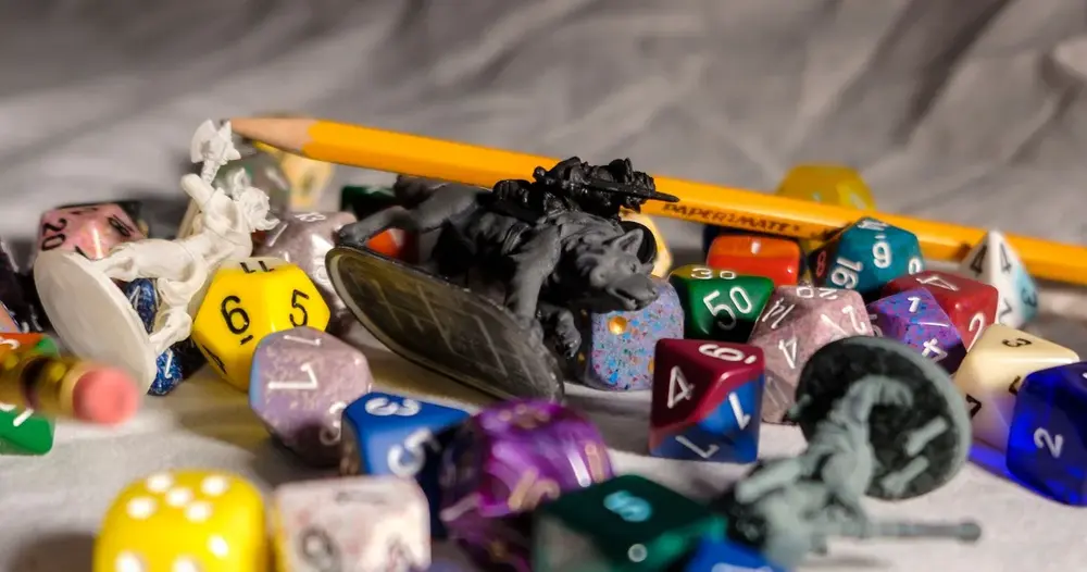 Dados de RPG coloridos e miniaturas sobre a mesa de jogo